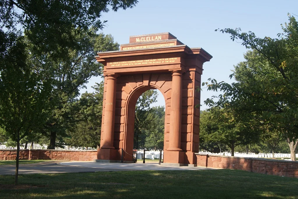 McClellan Gate at Arlington National Cemetery, a historic red sandstone archway framed by trees